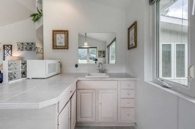 bathroom with vaulted ceiling and vanity