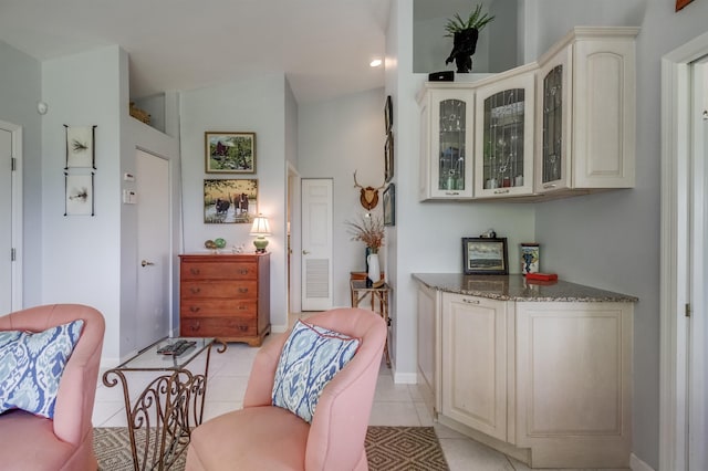 living area featuring vaulted ceiling and light tile patterned floors