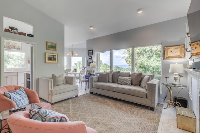 living room with light tile patterned flooring, plenty of natural light, an inviting chandelier, and a high ceiling