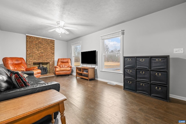 living room featuring baseboards, wood-type flooring, a textured ceiling, and ceiling fan