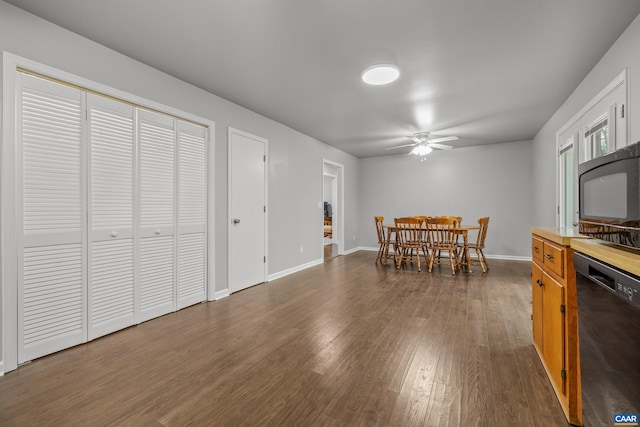 dining space with dark wood-style floors, baseboards, and ceiling fan