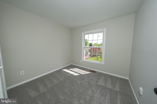 spare room featuring baseboards, carpet flooring, and visible vents