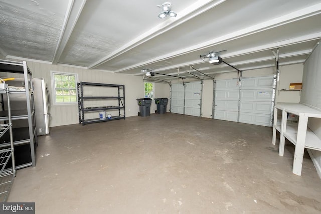 garage with a garage door opener and freestanding refrigerator