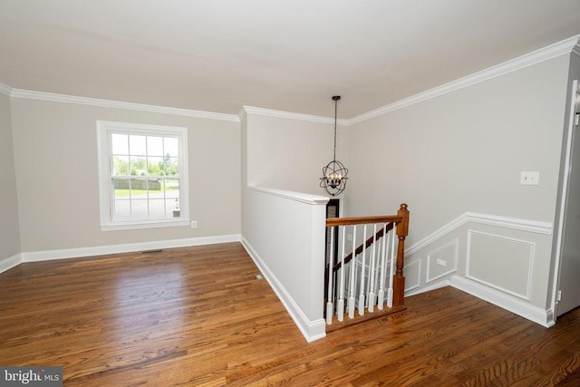 staircase featuring baseboards, ornamental molding, wood finished floors, and a notable chandelier