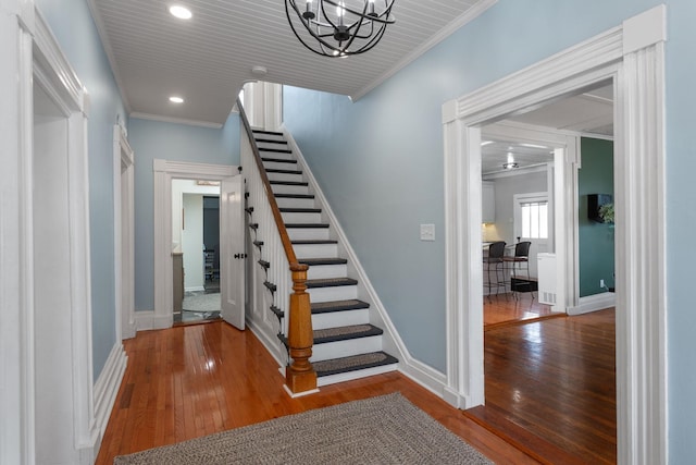 staircase with an inviting chandelier, baseboards, recessed lighting, and hardwood / wood-style floors
