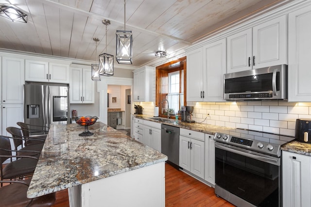 kitchen with a kitchen bar, a sink, wooden ceiling, white cabinets, and stainless steel appliances