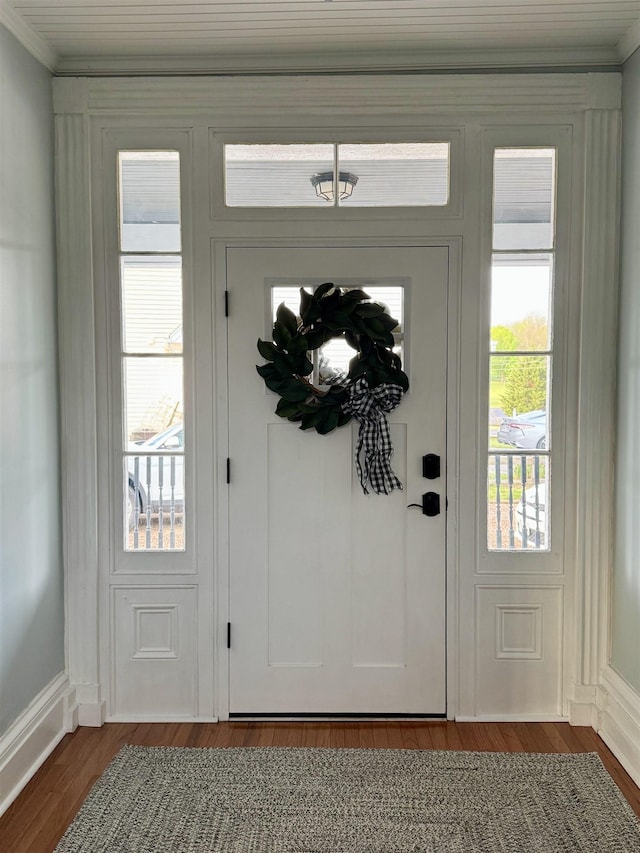 entryway featuring dark wood-type flooring and ornamental molding