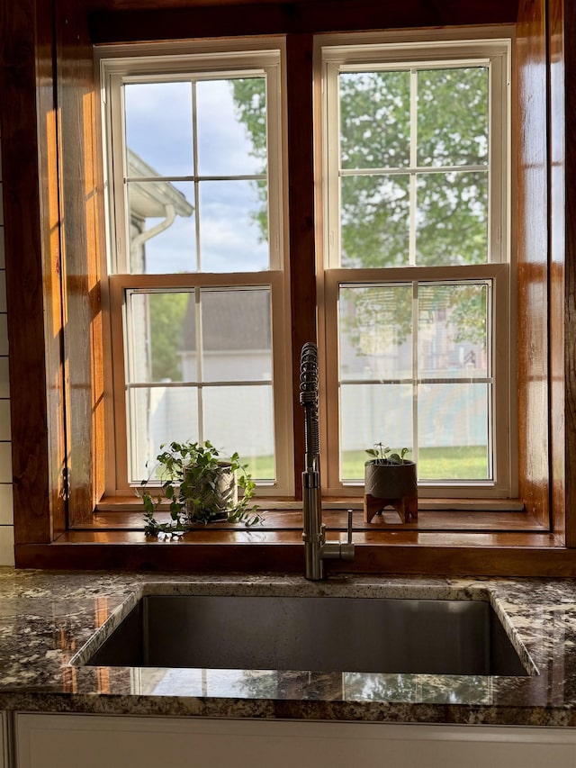 interior details with a sink and dark stone countertops