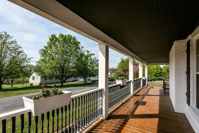deck featuring a porch and a yard