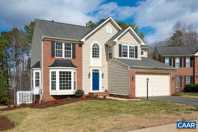 view of front of home with aphalt driveway, a garage, a front yard, and a shingled roof