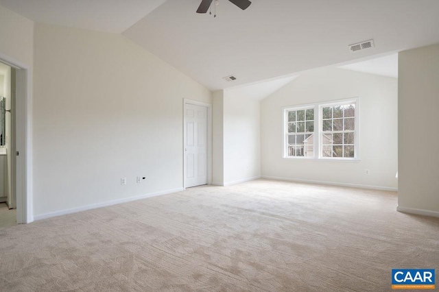 carpeted empty room with visible vents, baseboards, ceiling fan, and vaulted ceiling