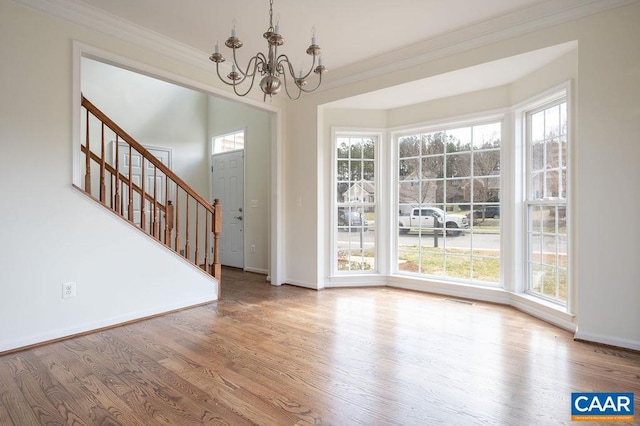 entrance foyer featuring a wealth of natural light, wood finished floors, and ornamental molding