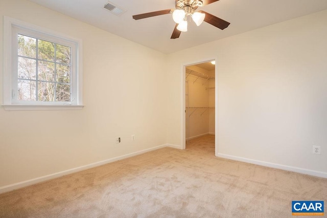 unfurnished room featuring a ceiling fan, carpet, visible vents, and baseboards