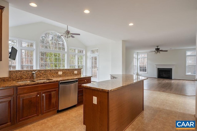 kitchen with a sink, plenty of natural light, dishwasher, and a fireplace