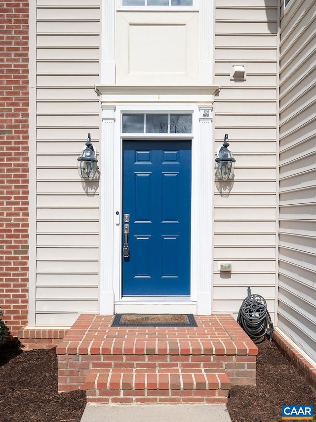 view of exterior entry with brick siding