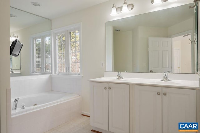 bathroom with double vanity, a tub with jets, tile patterned floors, and a sink