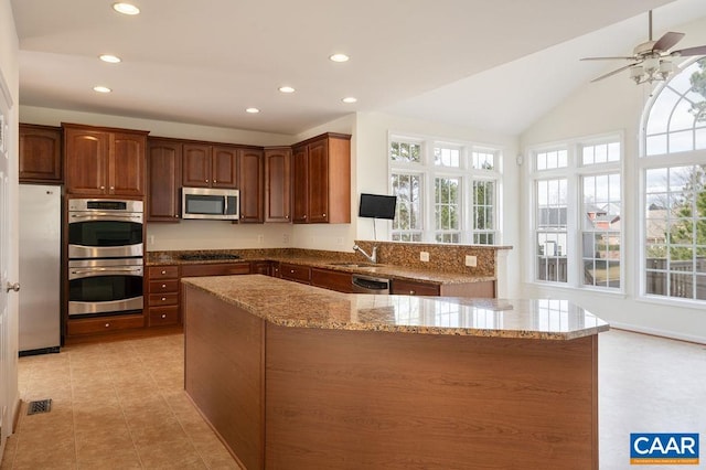 kitchen with light tile patterned floors, light stone countertops, recessed lighting, a sink, and stainless steel appliances