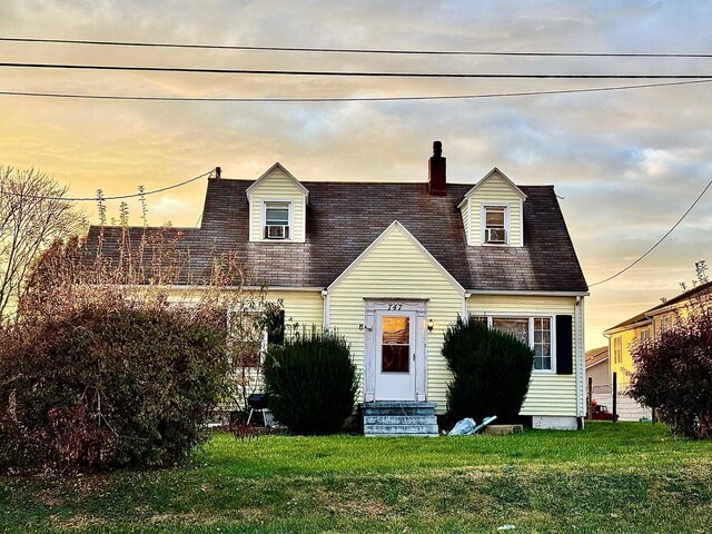 new england style home featuring a lawn