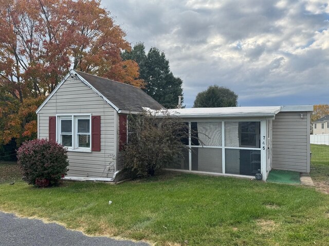 view of front of property with a front yard and a sunroom