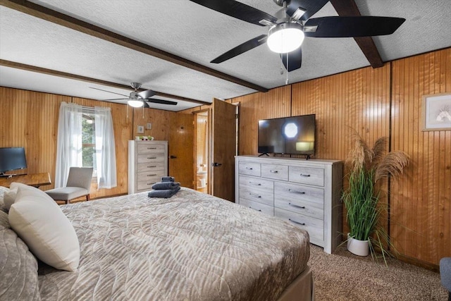 bedroom featuring wood walls, a textured ceiling, beamed ceiling, ceiling fan, and carpet