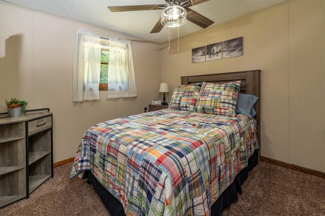 bedroom featuring dark colored carpet, a textured ceiling, and ceiling fan