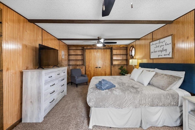 bedroom featuring beam ceiling, a textured ceiling, and carpet