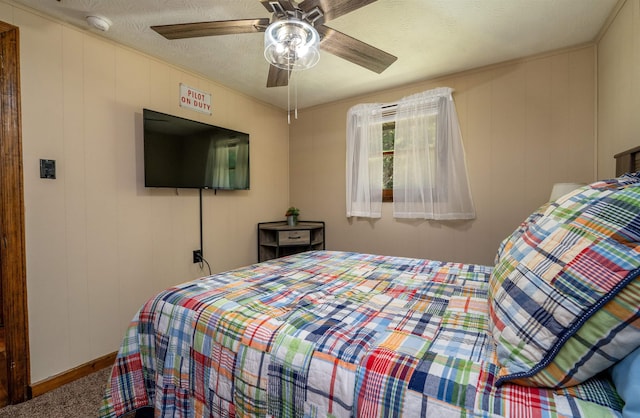 carpeted bedroom with ceiling fan and a textured ceiling