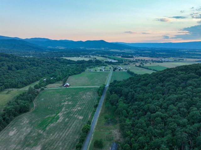 aerial view at dusk featuring a rural view and a mountain view