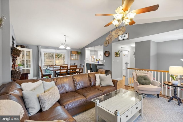 living room featuring ceiling fan, light hardwood / wood-style floors, and vaulted ceiling