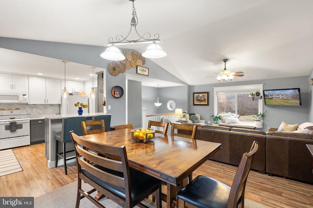 dining area featuring vaulted ceiling, ceiling fan, and light hardwood / wood-style floors