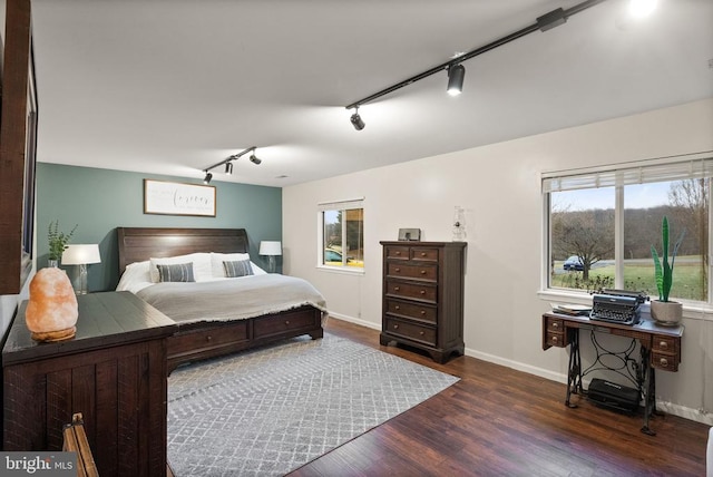 bedroom featuring track lighting and dark hardwood / wood-style flooring