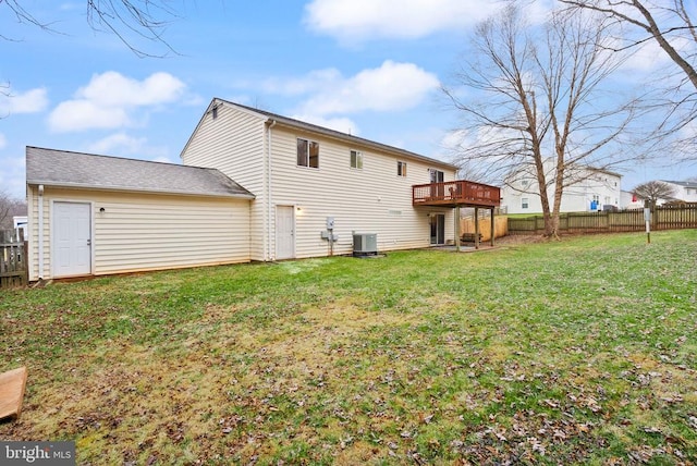 back of property with central AC unit, a yard, and a deck