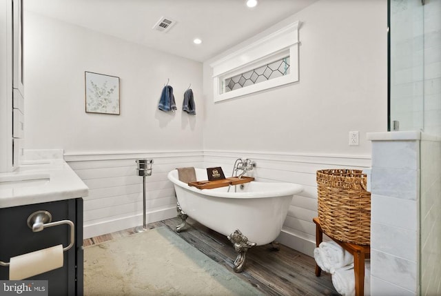 bathroom with vanity, independent shower and bath, and hardwood / wood-style floors