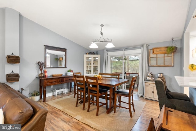 dining room with lofted ceiling and light hardwood / wood-style flooring