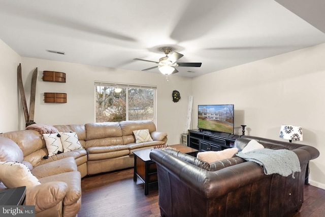 living room featuring dark wood-type flooring and ceiling fan