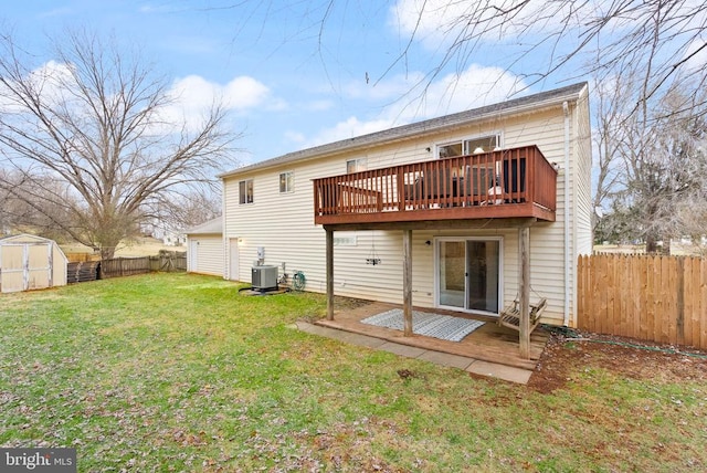 rear view of property with a shed, central AC, a lawn, and a deck