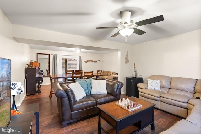 living room with dark wood-type flooring and ceiling fan