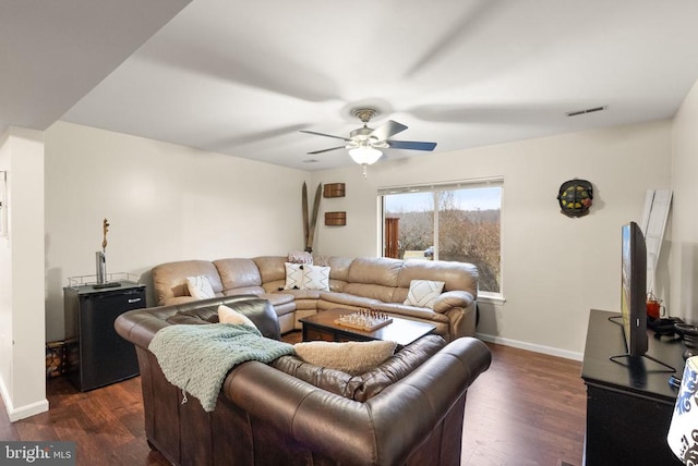 living room featuring dark wood-type flooring and ceiling fan