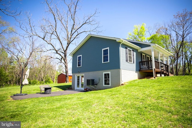 back of property featuring central AC unit, french doors, a patio area, and a yard