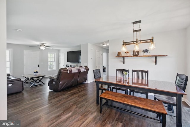 dining space with baseboards, a ceiling fan, and dark wood-style flooring