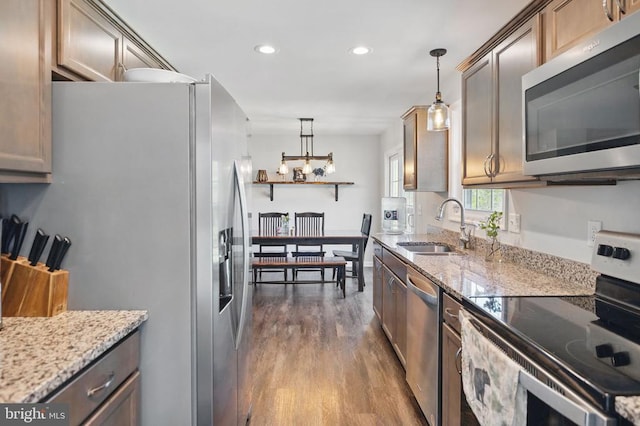 kitchen featuring decorative light fixtures, a sink, dark wood-style floors, stainless steel appliances, and recessed lighting