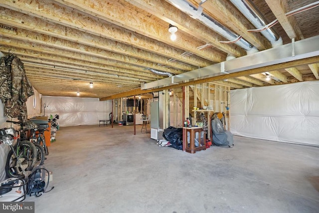unfinished below grade area with freestanding refrigerator and washer / dryer