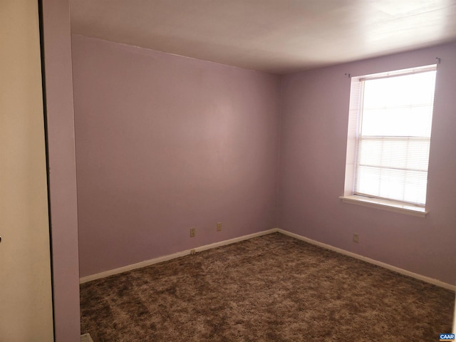 empty room featuring dark colored carpet