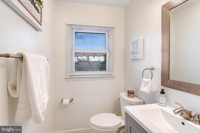 bathroom with baseboards, toilet, and vanity