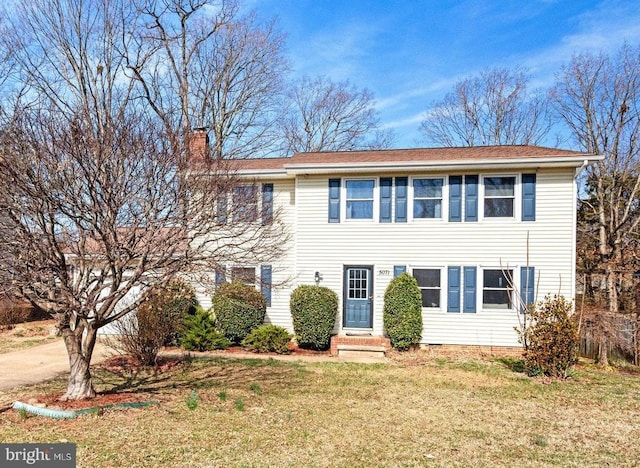 view of front of property featuring entry steps, a chimney, and a front lawn