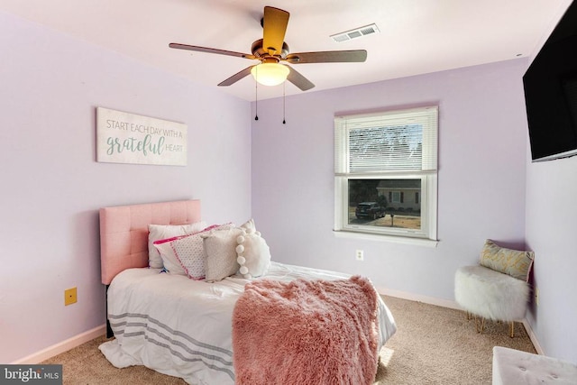 carpeted bedroom with visible vents, baseboards, and a ceiling fan