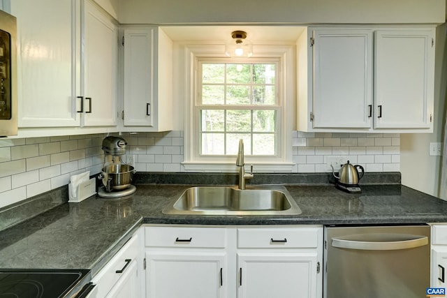 kitchen with stainless steel dishwasher, a sink, white cabinets, and tasteful backsplash