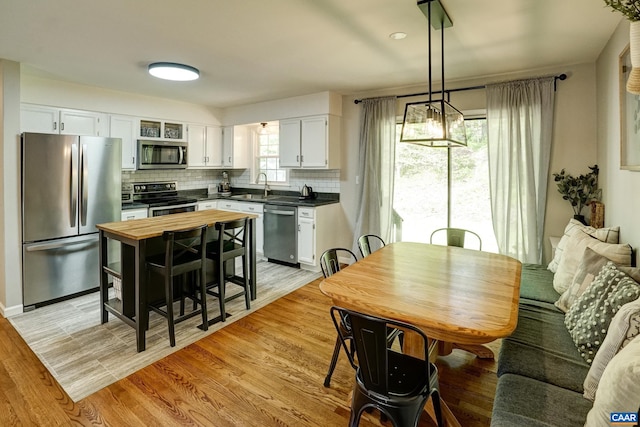 kitchen featuring tasteful backsplash, a sink, white cabinets, butcher block counters, and stainless steel appliances