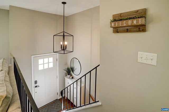 entryway featuring an inviting chandelier, stairs, and a towering ceiling