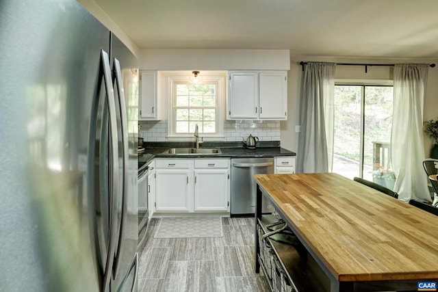 kitchen featuring a sink, white cabinetry, appliances with stainless steel finishes, and backsplash
